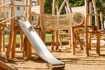Children Playground with Modern Swing Slide Wooden Climbing Equipment in Play Area. Entertainment Park for Kids in Nature.
