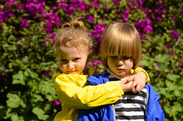 Fototapeta na wymiar Boy and girl in bright jackets. Brother and sister, first love, kindergarten. Children's hugs