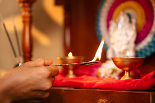 Close up shot of woman hands worshipping offering aarthi to god during morning - concept of rituals, traditional custom and spirituality.