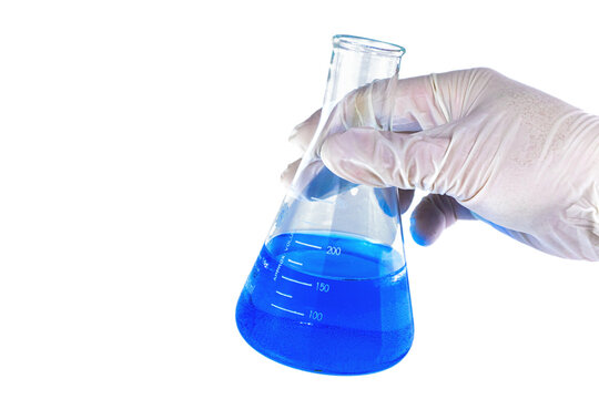 Hand holding a lab measurement glass on transparent background. Chemistry research. Blue liquid in the measurement glass. Experiment in the laboratory.  Chemical attempt, Laboratory experiment.
