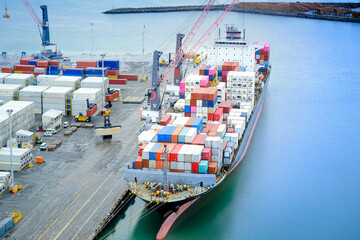 Aerial View of a Cargo Ship Being Loaded at a Bustling Port