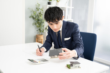 不動産価格を査定するビジネスマン