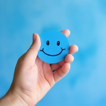Hand holding a blue paper cut smiley face, representing positive thinking and mental health assessment. AI generative.