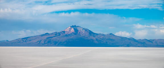 The shocking beauty of distant mountains across the huge salt expanses of the Salar de Uyuni, the...