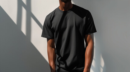 Minimalist Black T-Shirt Mockup: Young Athletic Man in Black T-Shirt in Studio against White Wall, Sunlight and Shadows