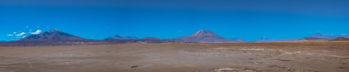 Fototapeta na wymiar Huge deserted plains in the Salar de Chiguana surrounded by majestic volcanos, Potosi department, Bolivia