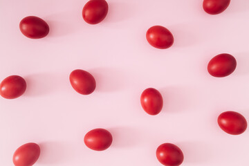 Creative Easter pattern composition made with red colored Easter eggs on light pink background. Minimal Easter concept. Spring holiday pattern background. Flay lay, top of view.