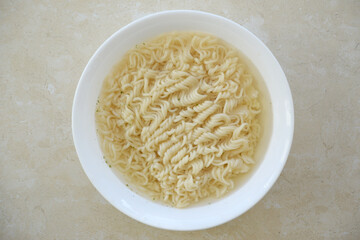 Bowl of instant cooking noodles on white marble table. Traditional asian food