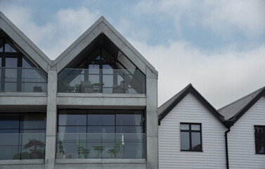 Modern hotel and house roof attics against cloudy sky. Home residential building. Traditional...