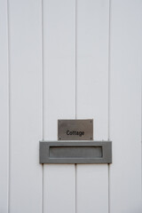 Traditional british cottage white door with mail box.