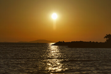 Calming summer sunset above wavy sea surface