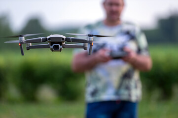 drone copter flying in the air with blurred man on background