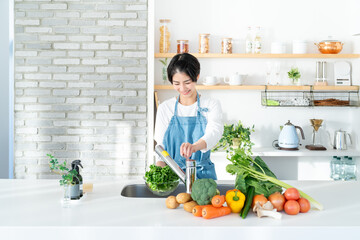 キッチンに立つ笑顔の若い女性