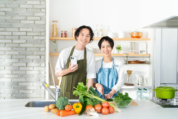 キッチンに立つ笑顔の若いカップル