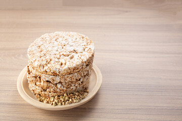 Buckwheat crisp bread on plate on wooden background, gluten free. Dietary cookies