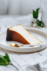 Popular Spanish dessert called San Sebastian cheesecake. It also known as burnt cheesecake. One piece of this dessert on white background.