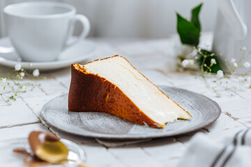 Fototapeta premium Popular Spanish dessert called San Sebastian cheesecake. It also known as burnt cheesecake. One piece of this dessert on white background.