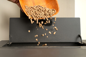 Closeup of a wooden basket filling a pellet stove. Sustainable and ecological heating