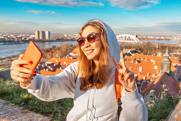 A woman captures her European adventure with a selfie in the historic streets of Novi Sad - obrazy, fototapety, plakaty