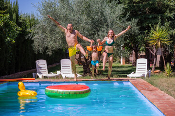 Joyful family screams have fun of mid-jump in resort pool