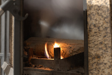 Lighting the fireplace.Fire burns in a fireplace, fire burns background, wood burning house,...