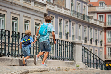 Fototapeta na wymiar Young explorers of Lisbon run in the streets