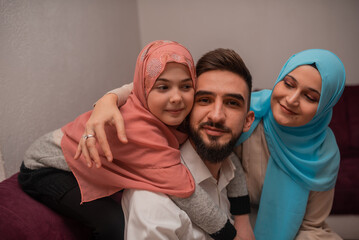 Happy Muslim Family at home. Smiling arabic mom, dad and daughter having fun together