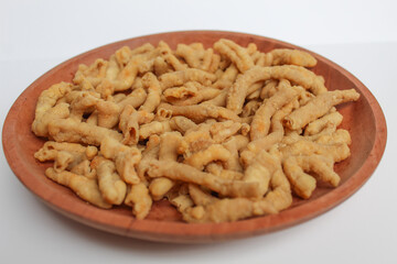 Crispy fried chicken intestines, on a wooden plate, isolated on white background