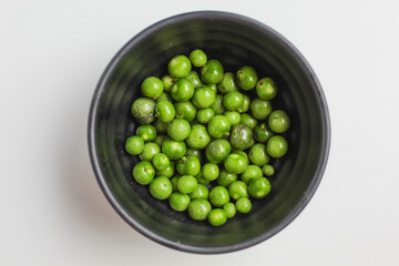 Fruit of Solanum nigrum, the European black nightshade or leunca, in a black bowl, isolated on white background, flat lay or top view