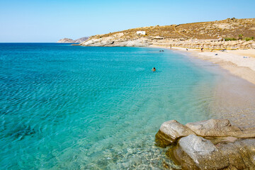 Fototapeta na wymiar Lia Beach, wild and free beach in the south of Mykonos, Greece. Pristine bay with blue sea and crystal water, famous for naturism and Scuba diving school, peaceful and quiet.