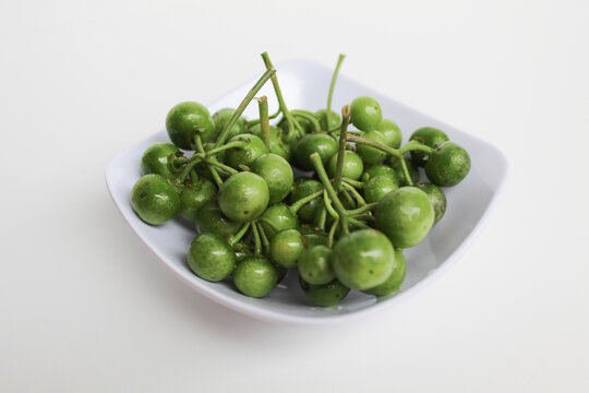 Fruit of Solanum nigrum, the European black nightshade or leunca, in a white bowl, isolated on white background