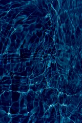 Water surface. Bluewater waves on the surface ripples blurred. Defocus blurred transparent blue colored clear calm water surface texture with splash and bubbles. Water waves with shining pattern.