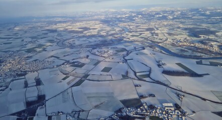 Aerial panorama of a snow covered winter landscape and fields covered with snow. Bavarian Winter landscape during sunrise from Top