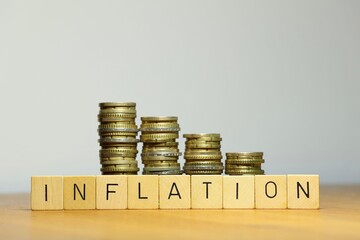 Idealised shot symbolizing inflation and lack of currency stability by decreasing coin stacks with...