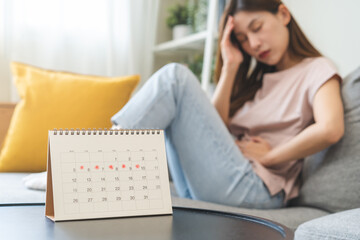 Menstruation, period cycle day of monthly, hurt asian young woman, female hand in stomach ache, suffer from PMS premenstrual, belly or abdomen pain on bed at home. Health problem Inflammation in body. - obrazy, fototapety, plakaty