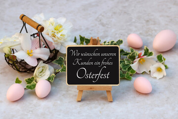 Frohe Ostern: Osterdekoration mit Blumenstrauß und Ostereiern. Kreidetafel mit dem Text wir...
