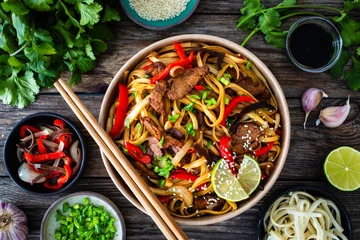 Fotobehang Asian style stir fried vegetables, roast beef and chow mein noodles  to go  in food box on wooden table  © Jacek Chabraszewski