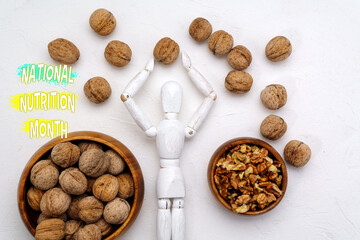 Celebrating National Nutrition Month With Healthy Choices - A Wooden Figure Surrounded by Walnuts
