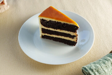 Piece of cake sits elegantly on a pristine white plate, offering a mouthwatering treat.