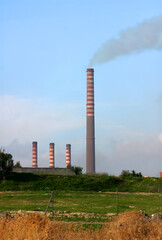 Fototapeta na wymiar Acciaierie d'Italia steel industry (formerly Ilva, ArcelorMittal and Italsider). Pollution from chimneys on Taranto, Puglia, Italy