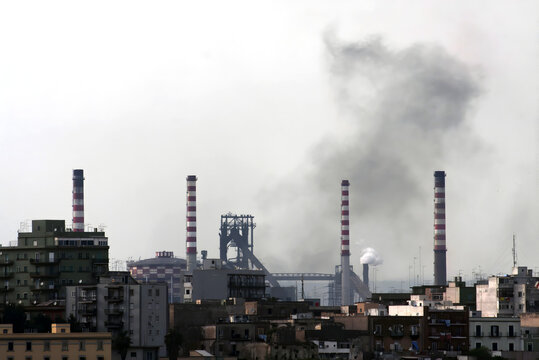 Acciaierie d'Italia steel industry (formerly Ilva, ArcelorMittal and Italsider). Pollution from chimneys on the Tamburi neighborhood of Taranto, Puglia, Italy