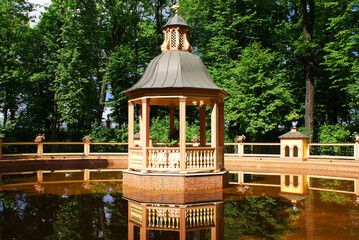 Gazebo for relaxation in a summer park near a pond, city park, wildlife.