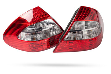 Stylish headlight stop signal made of white and red transparent glass on a white isolated background in a photo studio. Detail for replacement and sale in a car service.