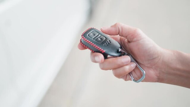 Locking and unlocking the car with the remote key When the car key button is pressed, the light will flash when the door is opened or closed. Female hand uses remote control key