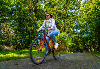 Mid-adult woman riding bicycle in city park
