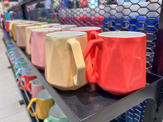 Ceramic cups of different colors and sizes close-up. Multi-colored cups covered with special glazed.