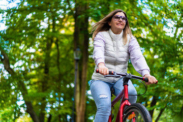 Mid-adult woman riding bicycle in city park
