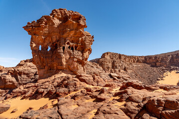 Tadrart landscape in the Sahara desert, Algeria. A curious rock formation in red sandstone where some sort of windows appear - 732652246