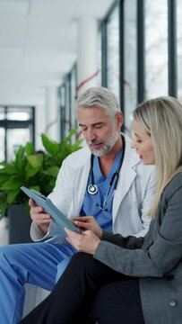Pharmaceutical sales representative talking with doctor in medical building. Ambitious female medical rep presenting new medication. Female hospital director with medical director.