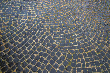 The road is paved with basalt cobblestones.